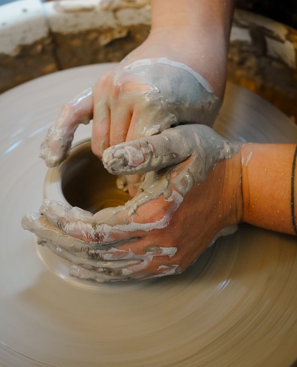Hands opening the floor of a form on the wheel